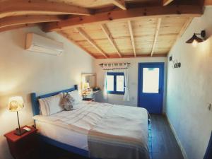 a bedroom with a large bed with a blue door at Alterna Köy Evi in Sokakagzi