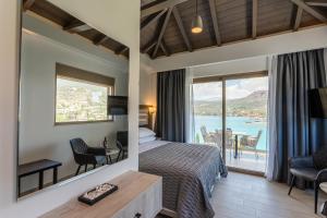 a hotel room with a bed and a view of the ocean at Lighthouse Apartments in Stoupa