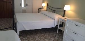 a bedroom with two beds and a dresser with a desk at Finestra sul porto in Marina di Camerota