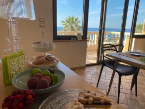 a table with a plate of food with a view of the beach at Le Camere di Rosanna in Marina di Gioiosa Ionica