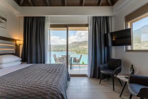 a hotel room with a bed and a view of the ocean at Lighthouse Apartments in Stoupa