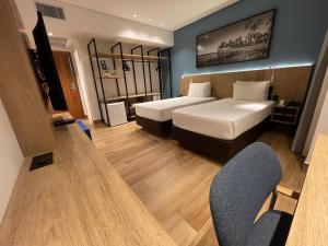 a hotel room with two beds and a tv at Hotel Senac Ilha do Boi in Vitória