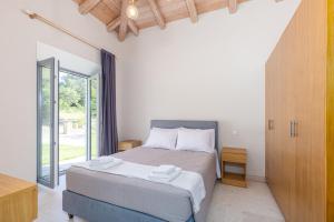 カト・コラキアナにあるVilla Dafni & Nikos Corfuのベッドルーム1室(ベッド1台、大きな窓付)