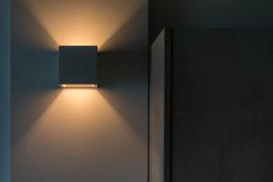 a light on a wall next to a door at Lighthouse Apartments in Stoupa