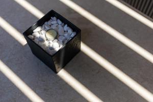 a black box filled with white rocks on a floor at Lighthouse Apartments in Stoupa