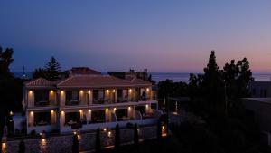a large house with lights on it at night at Lighthouse Apartments in Stoupa