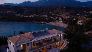 an aerial view of a house with a lake and mountains at Lighthouse Apartments in Stoupa