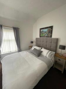 a bedroom with a large white bed and a window at Hill View House in Newry