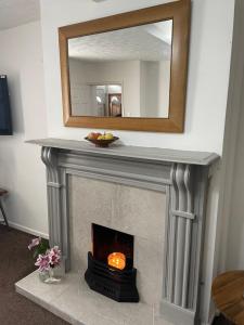 a fireplace with a mirror on top of it at Hill View House in Newry