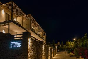 a building with a sign on the side of it at night at Lighthouse Apartments in Stoupa