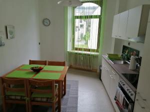 a kitchen with a small table and a kitchen with green walls at Mosel-Ferienwohnung Bewo in Bernkastel-Kues