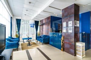 a salon with blue walls and blue chairs at Sunrise Hotel in Primorsko