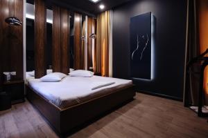 una camera con un letto con una parete nera di GS Premium a Yerevan