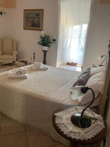 a bedroom with a large bed with a lamp on a table at B&b Donna Concetta in Felline