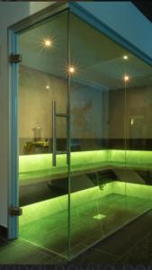 una camera con porta a vetri con luci verdi di Hotel Eccher 3 stelle Superior a Mezzana