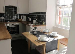 una cocina con una mesa de madera con platos. en 2 Chessels Court, Flat 3, en Edimburgo
