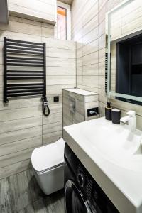 een badkamer met een witte wastafel en een toilet bij Stylish apartment in the center in Lviv