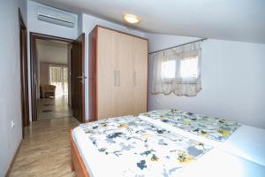a bedroom with a bed with a floral bedspread at Ferienhaus Elena in Karlobag