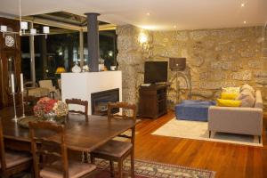 a living room with a table and a fireplace at Roque Village in Vieira do Minho