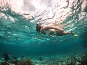 a woman swimming in the water with a frisbee at Portofino Beach Resort-An Authentic Island Escape! in San Pedro
