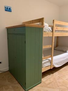 a green cabinet next to a bunk bed at Fafà Apartment in Naples