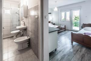 a bathroom with two toilets and a sink and a bed at Apartments & Rooms Strčić Krk in Krk