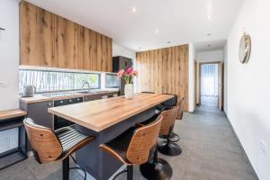 a kitchen with wooden walls and a wooden table and chairs at Holiday House Sukošan in Sukošan