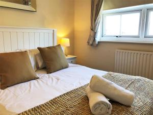 a bedroom with a white bed with pillows and a window at Garfield Place Cosy 2-Bedroom Cottage Central Windsor with Parking in Windsor
