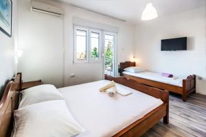a bedroom with two beds and a tv at Apartments & Rooms Strčić Krk in Krk
