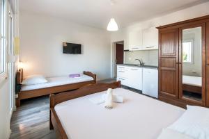 a small room with two beds and a kitchen at Apartments & Rooms Strčić Krk in Krk