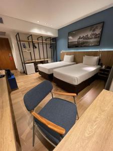 a hotel room with two beds and two chairs at Hotel Senac Ilha do Boi in Vitória