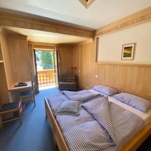 1 dormitorio con 2 camas y ventana en Garni al Barance, en Selva di Cadore