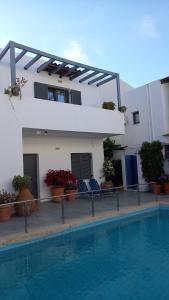 a hotel with a swimming pool in front of a building at Konaki Studios & Apartments in Panormos Rethymno