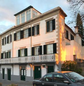 un bâtiment avec une voiture garée devant lui dans l'établissement Vitorina Corte Guesthouse, à Funchal