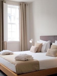 a bedroom with a large white bed with a window at Souto Guest House in Braga