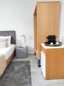 a bedroom with a bed and a desk with a laptop at Souto Guest House in Braga