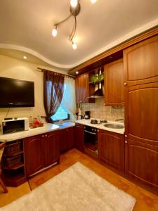 カリーニングラードにあるАпартаменты на Горькогоの木製キャビネットとテレビ付きの広いキッチンが備わります。