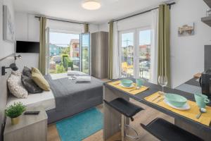 um quarto com uma cama e uma secretária com uma mesa sidx sidx em Valla Studio Apartments em Fažana
