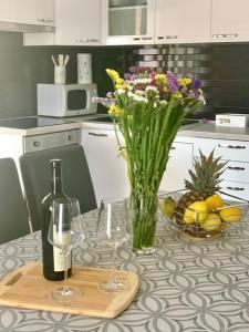 una mesa con una botella de vino y un jarrón de flores en *New apartment* PETRA, en Hvar