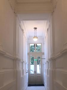 un pasillo vacío con una puerta y una lámpara de araña en Augartenblick Penthaus 17 - Blick zum Riesenrad, en Viena