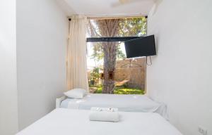 zwei Betten in einem Zimmer mit Fenster und Fernseher in der Unterkunft Bungalows Spilberg in Paita