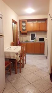 a kitchen with a table and chairs and a refrigerator at Antonioy Apartment Metewra in Kalabaka