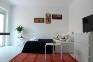 a white bedroom with a bed and a table at Apartman Boki in Pag