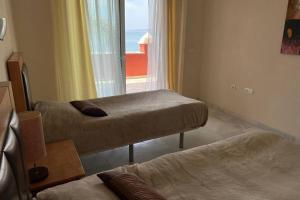 una camera con due letti e una finestra con vista di Estepona Seaview Apartment SELETUR a Estepona