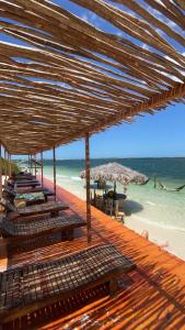 a wooden deck with chairs and umbrellas on a beach at Casa B&B in Jijoca de Jericoacoara