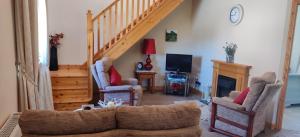 a living room with a couch and a staircase at Ferry View Cottage in Belmullet