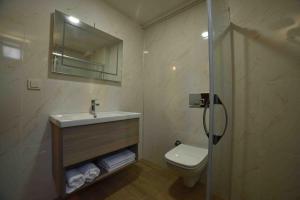 ein Bad mit einem Waschbecken, einem WC und einer Dusche in der Unterkunft Limnos Otel in Gokceada Town