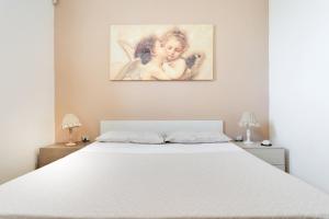 マティーノにあるCasa vacanze Gallipoliの白いベッドが備わる壁画のあるベッドルームです。