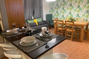 a living room with a table with plates and wine glasses at BLUE LAGOON - condomínio fechado LAGOA DE ÓBIDOS in Foz do Arelho