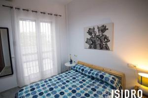 um quarto com uma cama com um edredão azul e 2 janelas em El patio de San Isidro by Gades Gestión em Cádiz